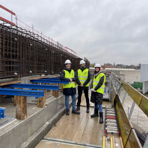 Rebar detailers and a project manager discussing reinforcement drawings at a construction site.