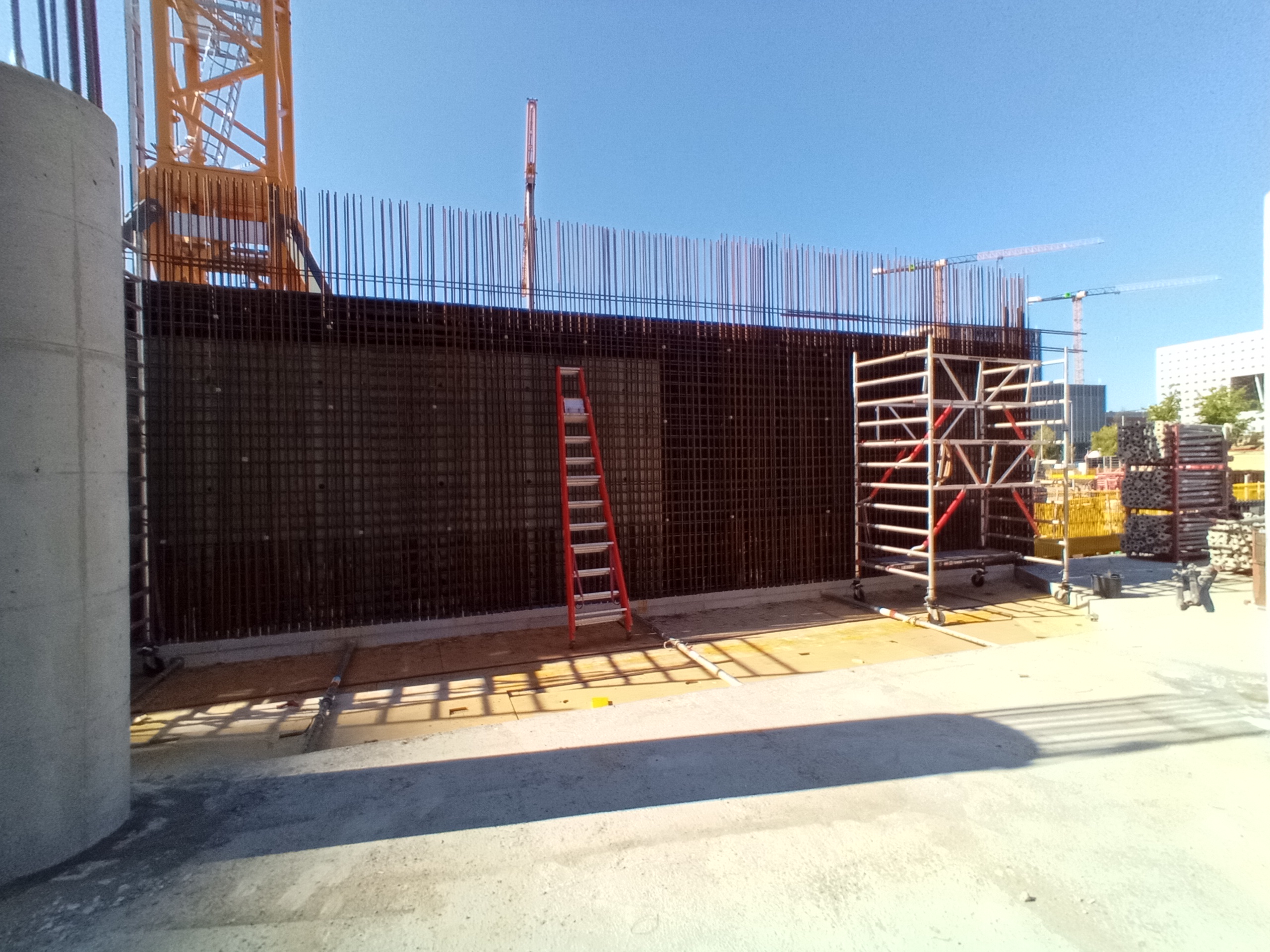 Construction in progress of a large-scale mixed-use building project showing multiple structural elements on site